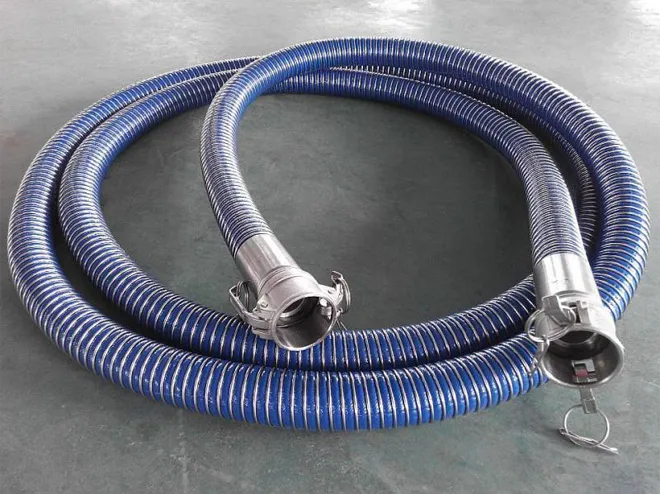 There is a blue composite hose coiled on the ground.